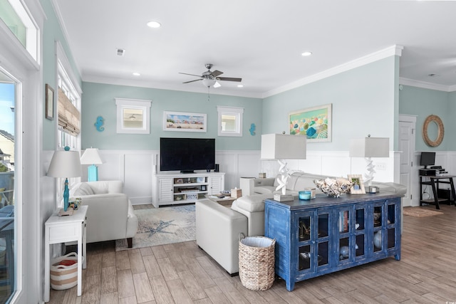 living room featuring light hardwood / wood-style flooring, ornamental molding, and ceiling fan