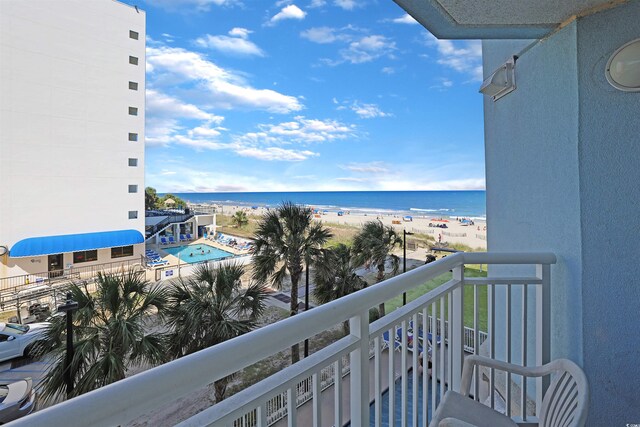 balcony featuring a view of the beach and a water view