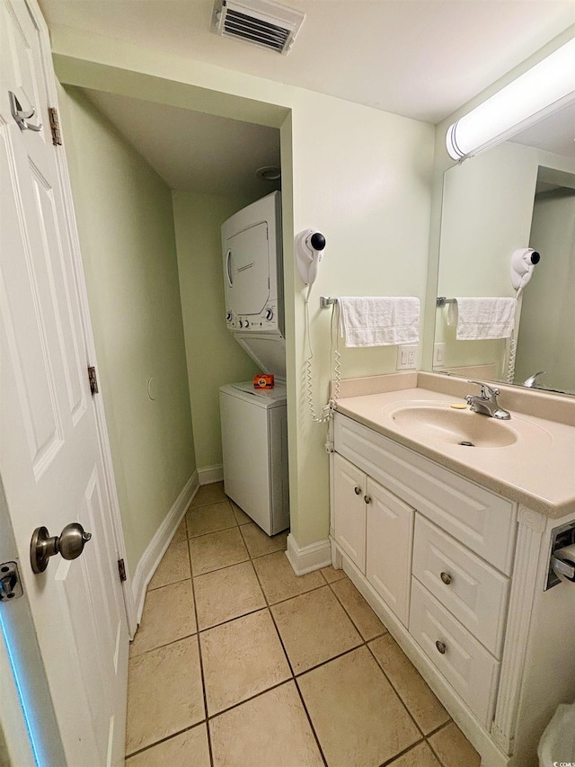 bathroom with stacked washer and dryer, vanity, and tile patterned floors