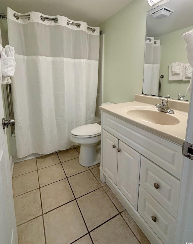 bathroom with tile patterned flooring, walk in shower, vanity, and toilet