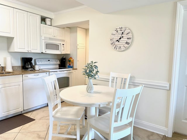 tiled dining room featuring ornamental molding and sink