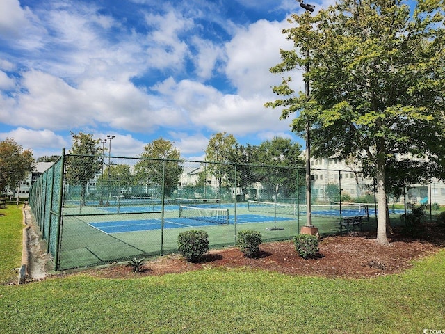 view of tennis court featuring a lawn