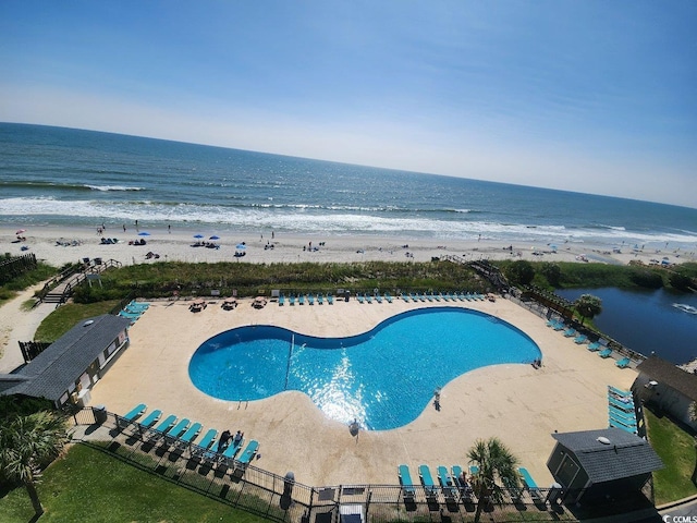 view of pool with a water view and a beach view