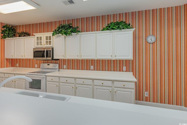 kitchen with white cabinetry, white range with electric cooktop, and sink