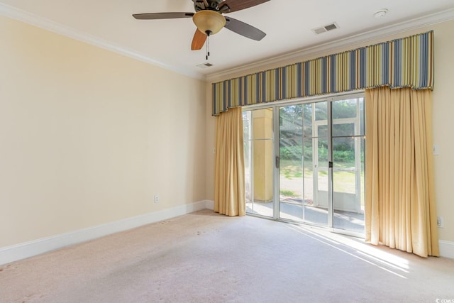 spare room featuring carpet, ornamental molding, ceiling fan, and a healthy amount of sunlight