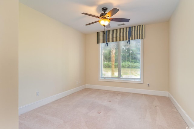 carpeted spare room featuring ceiling fan