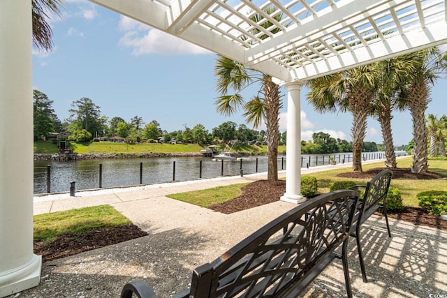 view of patio with a water view, a pergola, and a dock