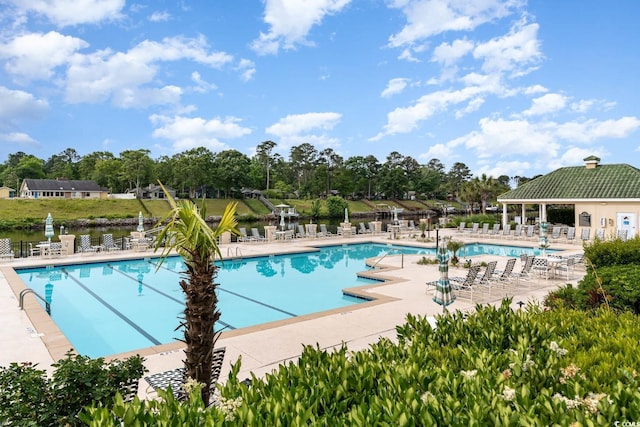 view of swimming pool with a water view and a patio area