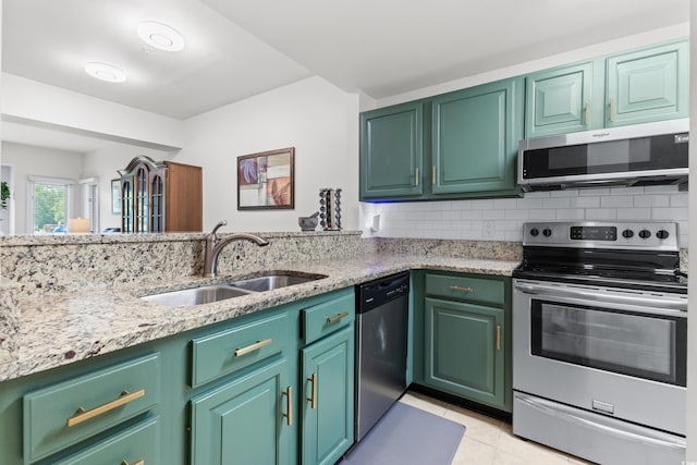 kitchen with backsplash, sink, green cabinets, and stainless steel appliances