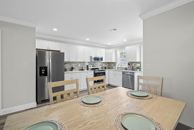 dining space featuring sink and ornamental molding