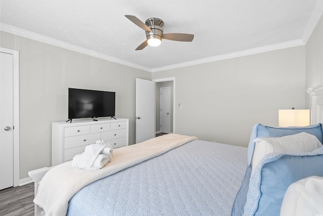 bedroom featuring crown molding, wood-type flooring, and ceiling fan