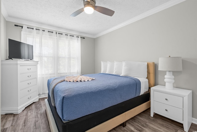 bedroom with hardwood / wood-style flooring, a textured ceiling, and multiple windows