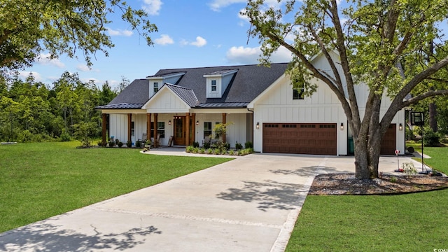 modern inspired farmhouse with a garage, a front yard, and covered porch