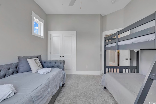 bedroom with a closet, ceiling fan, and light carpet