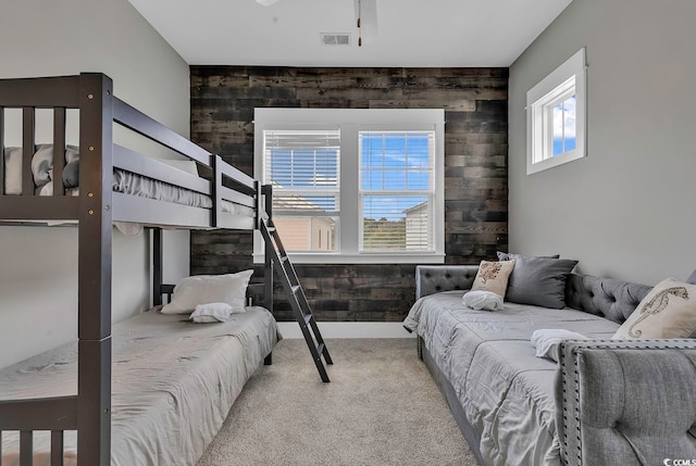 carpeted bedroom featuring wood walls