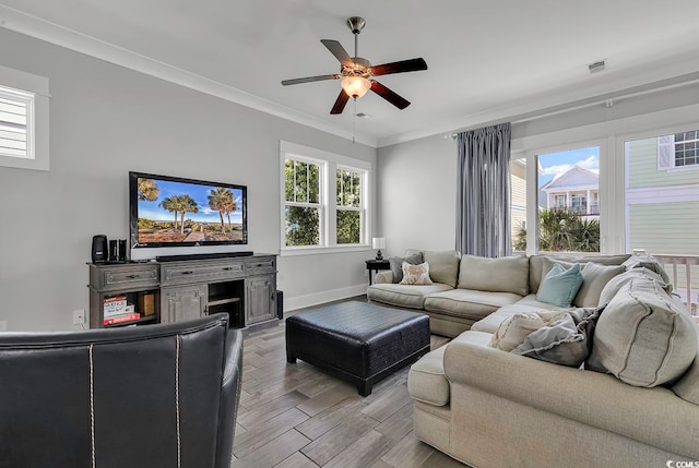 living room with ceiling fan, ornamental molding, plenty of natural light, and light hardwood / wood-style floors