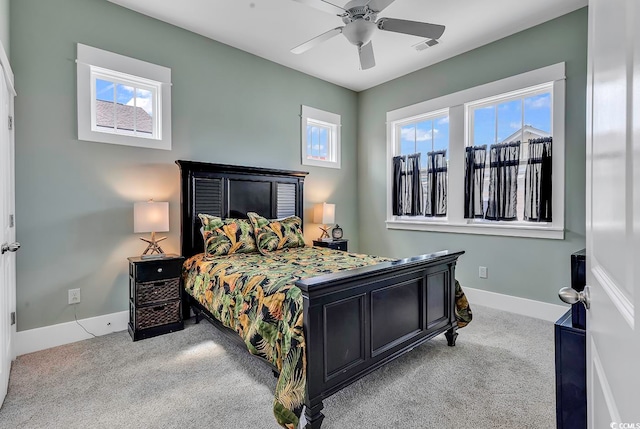 bedroom featuring ceiling fan, light colored carpet, and multiple windows