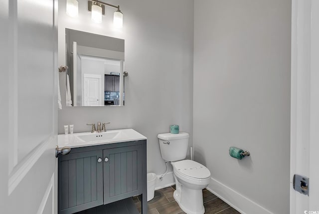 bathroom with hardwood / wood-style floors, vanity, and toilet