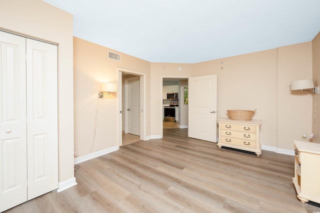 unfurnished bedroom featuring a closet and light hardwood / wood-style flooring