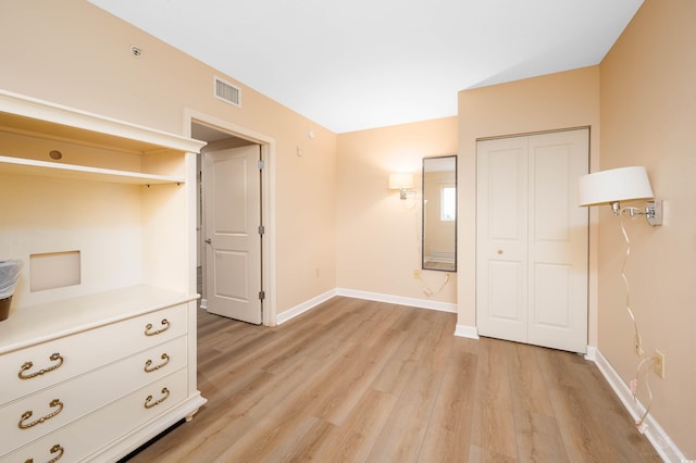 unfurnished bedroom with a closet and light hardwood / wood-style flooring