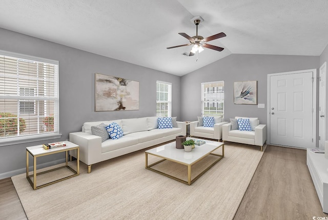 living room featuring plenty of natural light, lofted ceiling, light hardwood / wood-style floors, and ceiling fan