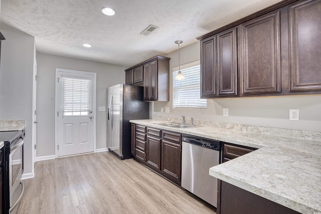 kitchen with sink, light wood-type flooring, stainless steel appliances, and a wealth of natural light