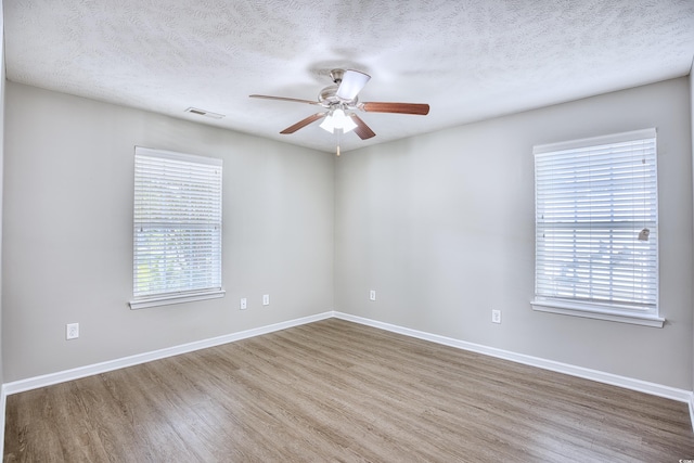 spare room with hardwood / wood-style flooring, a textured ceiling, and ceiling fan