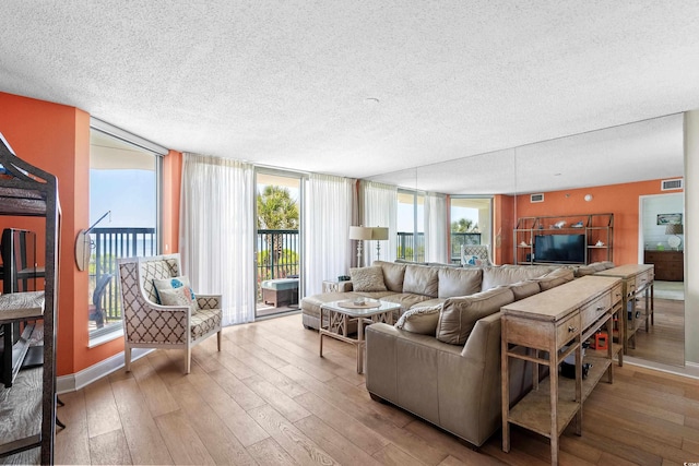 living room featuring light hardwood / wood-style flooring and a textured ceiling