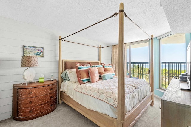 carpeted bedroom featuring access to outside and a textured ceiling