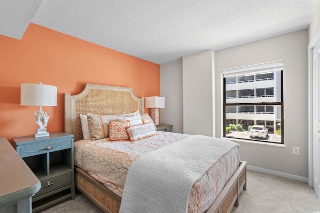 bedroom featuring light colored carpet and a textured ceiling