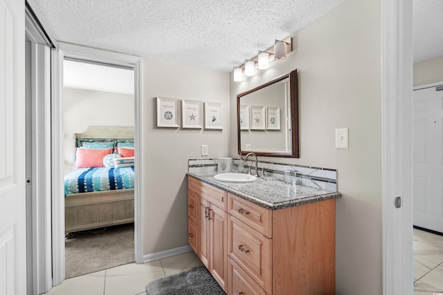 bathroom with tile patterned flooring, vanity, and a textured ceiling