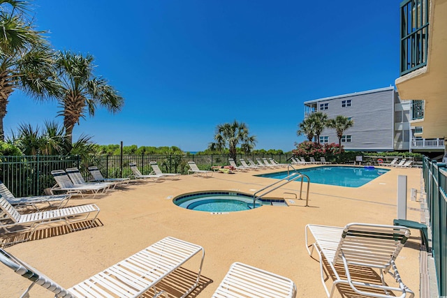 view of swimming pool with a hot tub and a patio