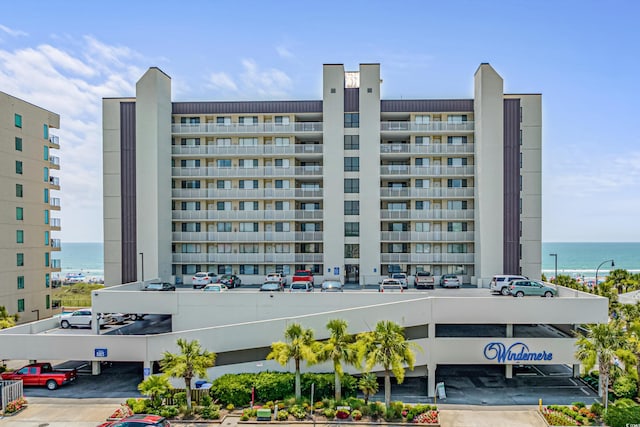 view of building exterior featuring uncovered parking and a water view