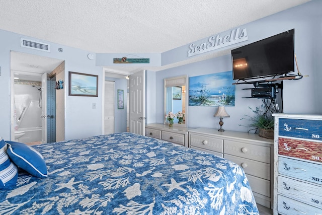 bedroom featuring visible vents, a textured ceiling, and ensuite bath