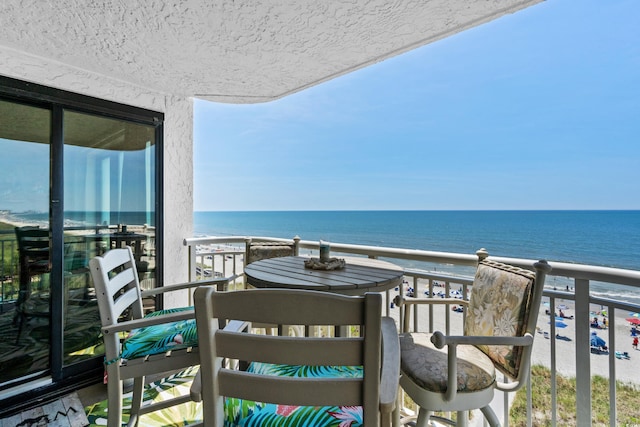 balcony with a water view and a beach view