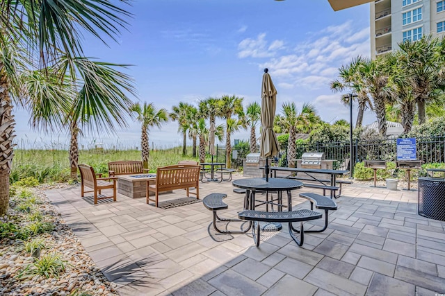 view of patio / terrace featuring an outdoor fire pit, grilling area, and fence