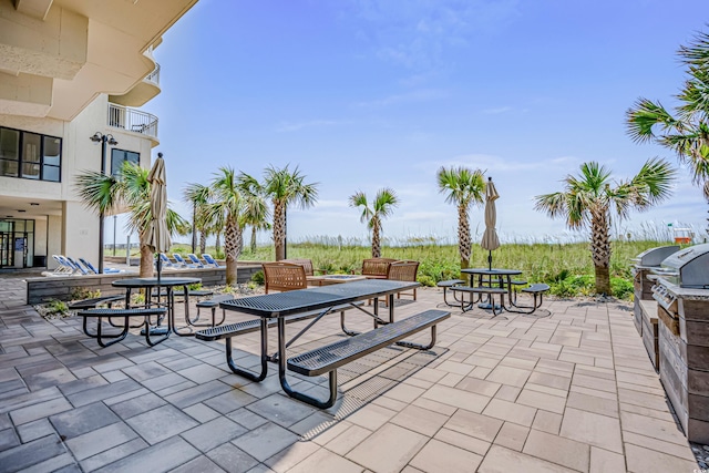 view of patio featuring exterior kitchen, outdoor dining area, a balcony, and area for grilling