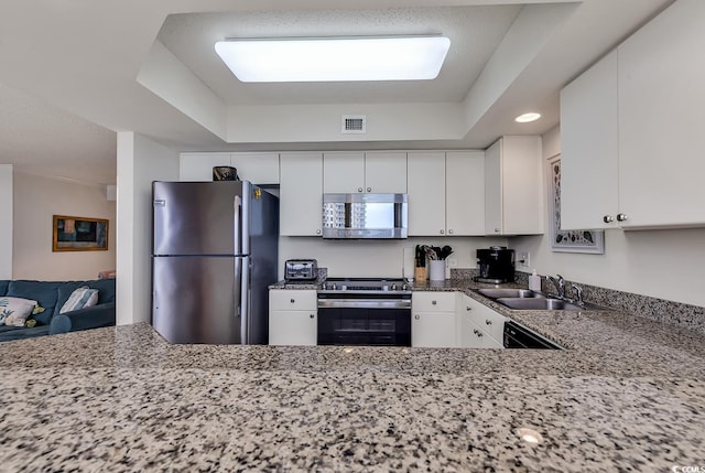 kitchen featuring white cabinets, light stone counters, sink, and appliances with stainless steel finishes