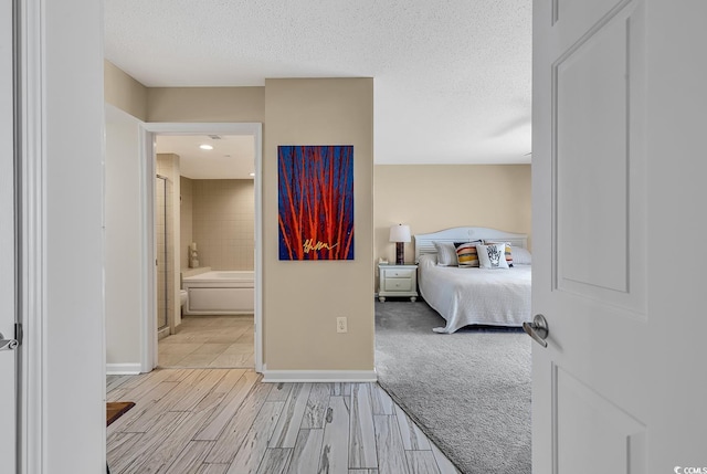 bedroom featuring ensuite bathroom and a textured ceiling