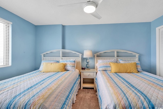 bedroom with carpet flooring, a textured ceiling, and ceiling fan