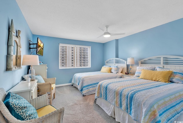 carpeted bedroom featuring ceiling fan and a textured ceiling