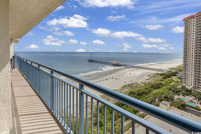 balcony featuring a water view and a beach view