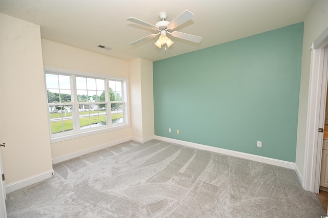 carpeted spare room with ceiling fan