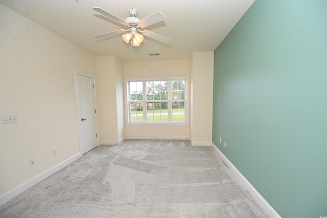 spare room with light colored carpet and ceiling fan