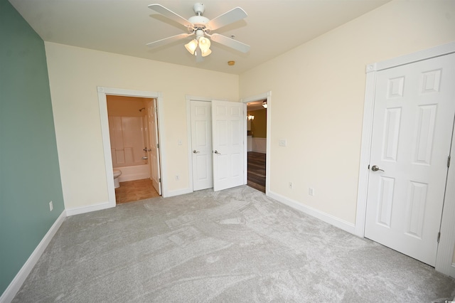 unfurnished bedroom featuring light carpet, ceiling fan, and ensuite bathroom