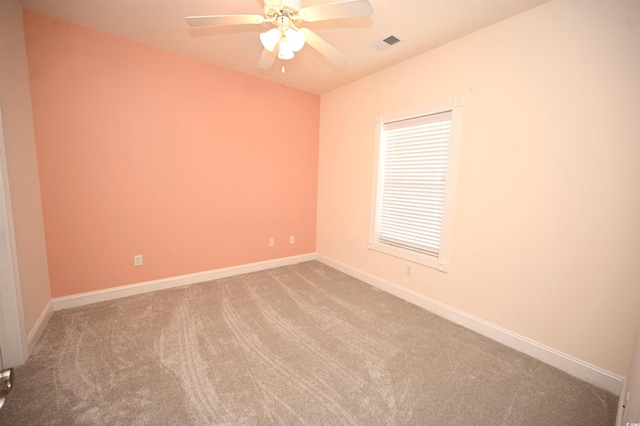 carpeted spare room featuring ceiling fan