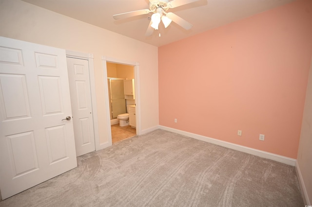 unfurnished bedroom featuring ensuite bathroom, light colored carpet, ceiling fan, and a closet