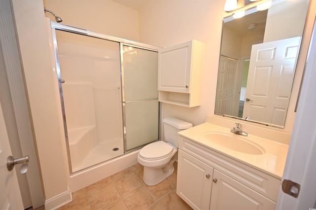 bathroom featuring vanity, a shower with shower door, tile patterned floors, and toilet