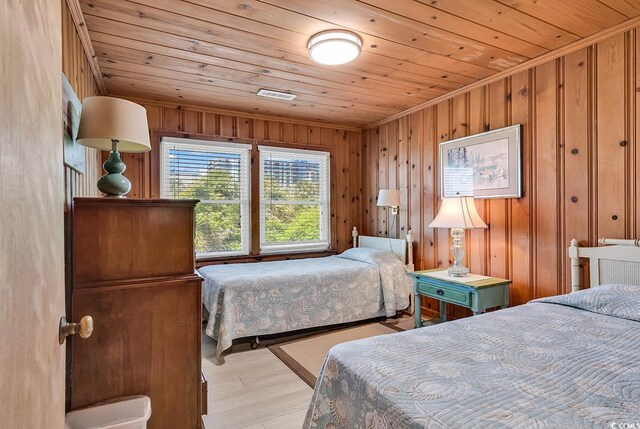 bedroom featuring light hardwood / wood-style floors, wooden ceiling, and wooden walls