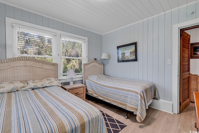 bedroom featuring light hardwood / wood-style floors, ornamental molding, and wood ceiling